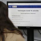 Mulher acessa o site para agendamento da vacina contra a Covid-19, em Joinville