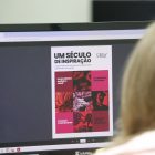 Mulher vê exposição de Victor Kursancew no site da prefeitura