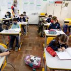 Alunos em sala de aula respeitando o distanciamento e usando máscara