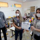 Agentes da Vigilância Ambiental entregam certificado de honra ao mérito a professora em sala de aula