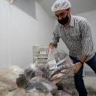 Trabalhador armazena peixes doados