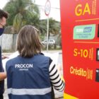 Dois fiscais do Procon conferem preços em um posto de combustível