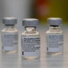 três frascos de vacina da pfizer estão em cima de uma mesa
