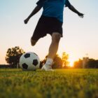 Homem joga futebol de campo