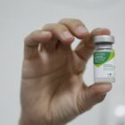 Profissional segura frasco com vacina contra a gripe