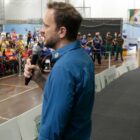 Prefeito Adriano Silva discursa ao lado do secretário de Esportes André Mattos para uma plateia sentada