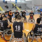 Time de basquete em cadeira de rodas reunido em roda