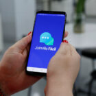 Mãos femininas seguram celular com o aplicativo Joinville Fácil