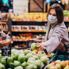 Mulher escolhe maças em supermercado