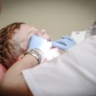 Dentista examina boca de criança