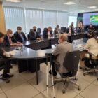 Prefeito Adriano Silva sentado em volta de uma mesa com outras autoridades