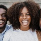Três jovens negros estão sorrindo