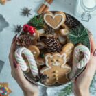 Imagem de um arranjo de Natal com doces segurado por uma mulher