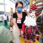 Feirante mostra artesanato de Papai Noel que é comercializado