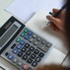 mulher faz cálculo em calculadora