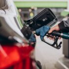 Frentista abastece carro em posto de gasolina