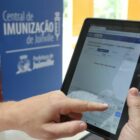 Profissional da saúde usa tablet na Central de Imunização