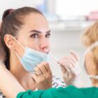 Profissional aplica teste com cotonete em nariz de paciente