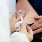Profissional da saúde se prepara para aplicar vacina em paciente