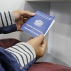 Jovem com Carteira de Trabalho em mãos