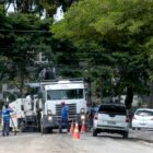 Caminhões e homens trabalham na sinalização de rua