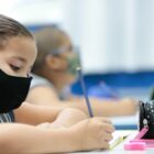 alunas em sala de aula escrevendo no caderno