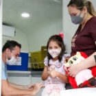 Menina recebe a vacina contra a Covid-19 ao lado da mãe
