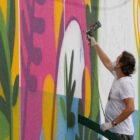 artista faz a pintura no muro do CEU do Aventureiro