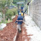 Homens trabalham em escavação para implantar tubos