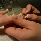 Foto de uma manicure fazendo a unha de uma cliente