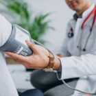 Médico afere pressão arterial de paciente