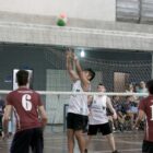 Alunos jogam volei em uma quadra