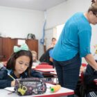 Professora auxilia alunos em atividades em sala de aula