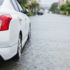 carro trafega em rua alagada