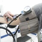 paciente mede a pressão arterial com aparelho no braço