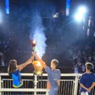 Dois alunos seguram tocha no palco para representar o início dos jogos