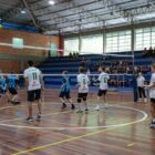 Duas equipes de alunos competem na modalidade vôlei, em quadra.