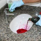 Técnico joga líquido em pia para verificar vazamentos