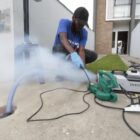 Homem trabalha com ferramentas para abrir o pavimento e instalar ligação de esgoto
