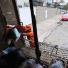 Coletor de lixo despeja sacos dentro do caminhão de coleta