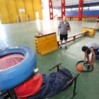 Crianças jogam bola em aro de basquete formado por pneu