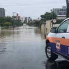 carro da Defesa Civil em rua com alagamento