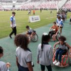 crianças brincando na modalidade paradesportiva de corrida em cadeira de rodas