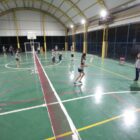 Alunas treinam badminton em quadra esportiva