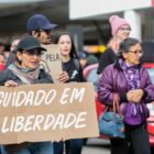 mulher segura cartaz com o dizer cuidado em liberdade durante a caminhada
