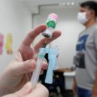 profissional de saúde coloca vacina contra a gripe em seringa