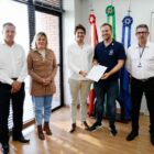 Prefeito, vice, secretário e diretores da empresa seguram papel da assinatura de convênio