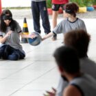 alunos vendados e sentados no chão fazem atividade coletiva