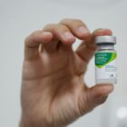 Pessoa segura o frasco com vacina