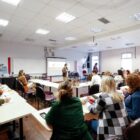 Professores reunidos em uma sala, ouvindo um palestrante